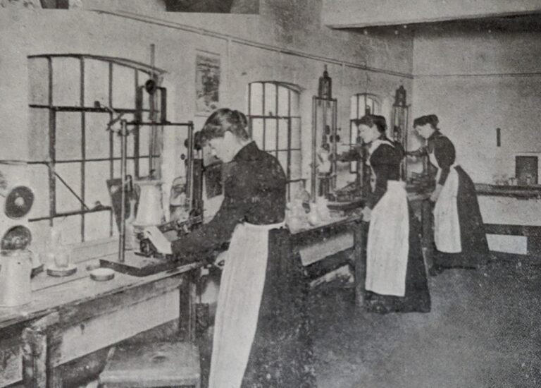 This image depicts women workers in year approx 1900 in the etching department, in which pantograph machines are being used to etch geometrical patterns onto the glass.